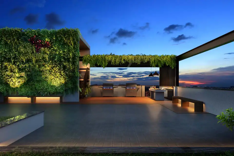 A roof terrace at blue hour with a planted green wall and the city on the horizon